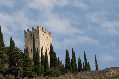 Colodri dağının tepesindeki Castello di Arco (Arco kalesi) manzarası. Kolodri duvarı dağcılar için popülerdir. Manzara Arco köyünün merkezindeki bir atari salonunun altından.