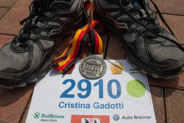 Berlin, Almanya - 30 09 2007: Yarış önlüğü ve koşu ayakkabılarıyla bir maraton finalisti madalyasının kapanışı. Madalya 2007 Berlin Maratonu 'ndan, en ünlü 5 maratondan biri ve en hızlısı.