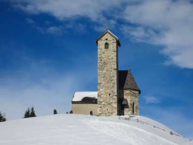 Monte San Vigilio 'nun üstündeki küçük Aziz Vigilio Kilisesi kışın karla kaplanmış Vigiljoch. Dağ, Güney Tyrol 'daki Lana köyünün üzerinde.