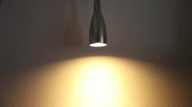 Karanlık bir odada loş bir ışık ve duvardaki etkisi. Işığın parlaklığı artar ve azalır. Loş ışık küçük bir ışığa ayarlı.