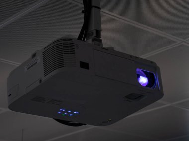 Bir iş sunumu sırasında aydınlatılan bir projektörün kapanışı. Projektör bir ofisin, toplantı odasının ya da sınıfın tavanına sabitlenir.
