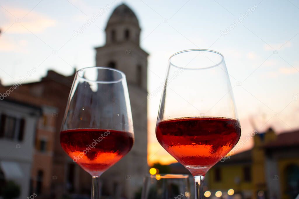 Two glasses on red wine ready to be drunk in the sunset of Sirolo. The wine is Rosso Conero and the dusk is in the most popular tourist location of Riviera del Conero in Italy