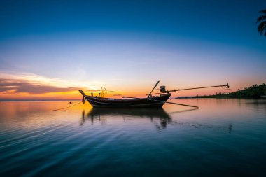 Tayland 'daki Wok tum Sahili Phangan Adası' nda uzun kuyruklu tekneler (geleneksel tekneler) ile gün batımının silueti