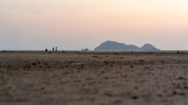 Hin Kong Sahili 'nde günbatımı sahnesi ve ufukta savaş gemileri. Phangan Adası, Tayland. Gürültü renk ve seçici odak.