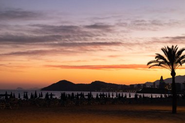Benidorm sahilinde gökyüzünde bulutlarla gün batımı (Alicante, Valencia). insanlar olmadan