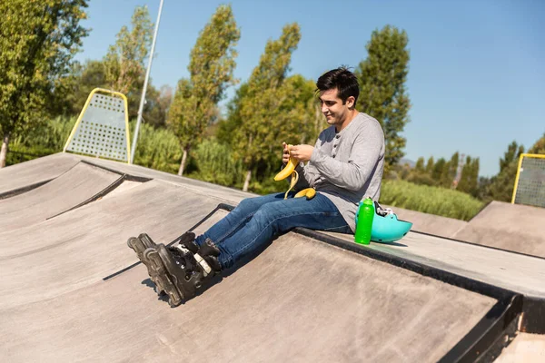 Boy Roller Skates Eating Banana Sitting Public Skate Park Has — Stock Photo, Image