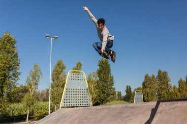 Kafkas kökenli kaykaycı çocuk kaykay parkından atlayıp havada bir numara yapıyor..