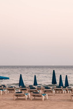 Benidorm plajı boş, insan yok. Hamaklar, şemsiyeler, bulutlu bir gün. Salgın, koronavirüs