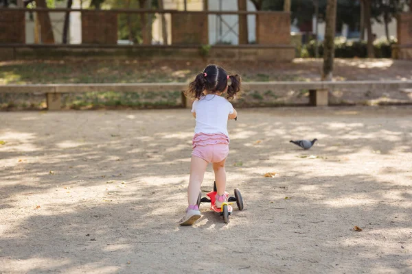 Kislány Hátán Egy Piros Fekete Robogón Játszik Lovagol Egy Parkban — Stock Fotó