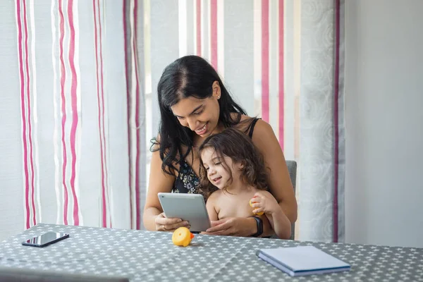 Madre Figlia Ispanica Usano Tablet Seduti Una Sedia Davanti Tavolo — Foto Stock