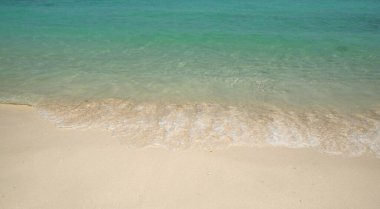 Yaz tatili dekorasyonu için temiz deniz suyu ve beyaz kumsal arka planı.