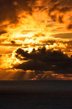 Parlak günbatımı ışığıyla aydınlanan karanlık bulutların görüntüsü