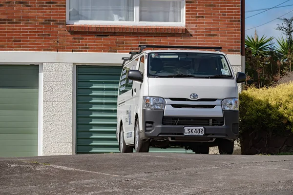 Auckland / Yeni Zelanda - 28 Mart 2020: Banliyö tuğla evinin önüne park edilmiş beyaz Toyota Hiace ticari minibüsü