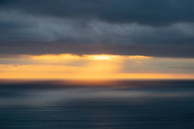 Piha sahilindeki Tasman sahili üzerindeki akşam bulutlarının uzun hava görüntüsü.
