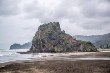 Bulutlu bir günde Piha Lion Rock 'ın görüntüsü