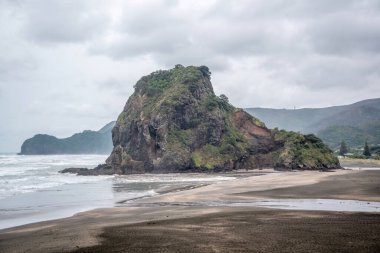 Bulutlu bir günde Piha Lion Rock 'ın görüntüsü