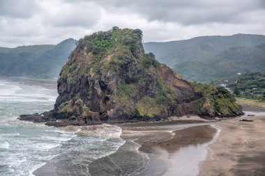 Bulutlu bir günde Piha Lion Rock 'ın görüntüsü