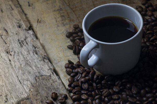 Coffee beans and espresso on wood background