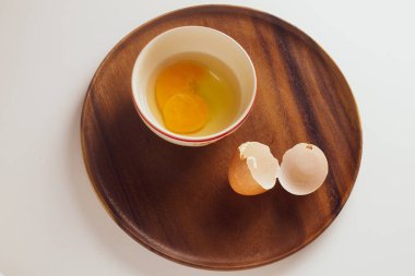 Tahta tabakta yumurta ve fincanla yemek pişirmeye hazırlanın.