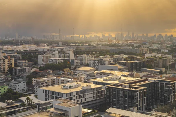 View of expanding city, changing environment. In the evening, the sun shines through cloudy sky and rain from the tower, The full-length landscape with buildings and architecture of Bangkok Thailand.