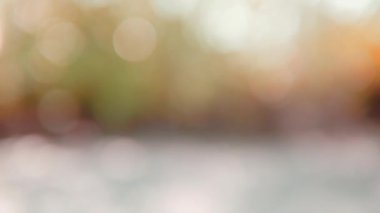 Soyut bulanık sonbahar arkaplanı, odağını kaybetmiş sonbahar yapraklarının renkli bokeh 'ini hareket ettiriyor. Ağaçlar güneş ışığına karşı çok renkli yapraklar dökülüyor..