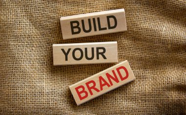 Ahşap bloklar, güzel tuval arkaplanı üzerine 'brandanızı inşa edin' metnini oluşturur.