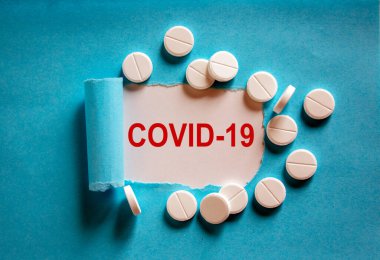 COVID-19 Pandemic Coronavirus konsepti. Yırtık mavi kağıdın arkasında 