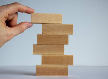 Başarı temeli konsepti. Kadınlar ahşap blokların üzerine ahşap bloklar koyarlar..