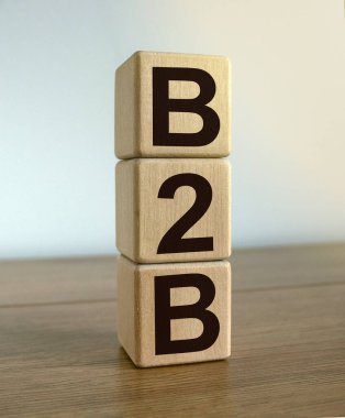 Küpler üzerinde güzel beyaz bir arkaplanda 'B2B' kavramını kullan. Tahta masa. İş konsepti.