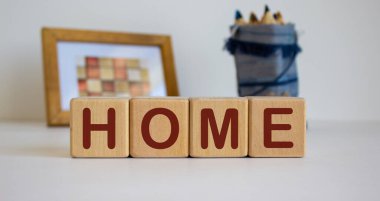 Evinde yazı olan tahta küpleri. Resimli bir çerçeve ve arkasında kalemler olan bir çanta..