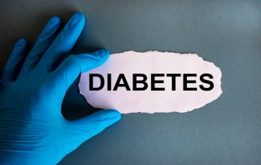 Beyaz küçük kağıtlı mavi eldiven verin. Diyabet kavramı. Mavi arka plan. Boşluğu kopyala.