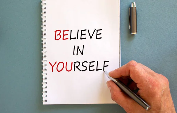 Male Hand Writing Believe Yourself White Note Isolated Blue Background — Stock fotografie