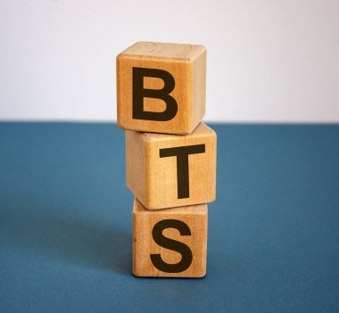 Üzerinde 'BTS' yazan tahta küpler. Güzel mavi tablo ve beyaz arkaplan, boşluğu kopyala.