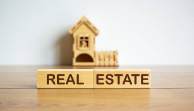 Bloklar, minyatür bir evin önünde gayrimenkul kelimelerini oluşturur..