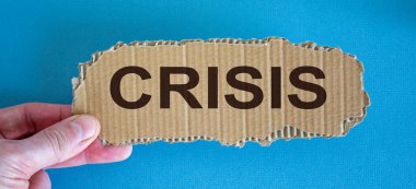 Parmaklar arasındaki karton parçasında kelime krizi.