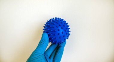 COVID-19 Pandemic Coronavirus konsepti. Doktor elinde koronavirüsün soyut bir modelini tutuyor. Eldivenli el.