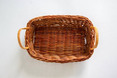 Güzel beyaz bir arka planda küçük boş bir hasır sepet. Boşluğu kopyala.