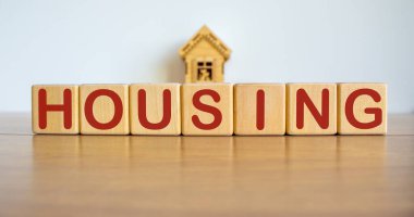 Bloklar, minyatür bir evin önünde 