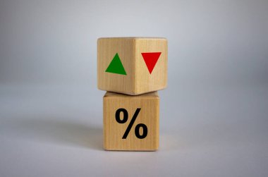 Wooden cubes changes the direction of an arrow symbolizing that the interest rates are going down or vice versa . Business concept. Copy space. clipart