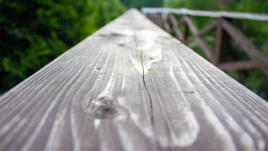 Eski ahşap kaplama. Arka planda bulanık bir göl ve park.