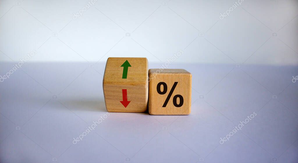 Wooden cubes changes the direction of an arrow symbolizing that the interest rates are going down or vice versa . Business concept. Copy space.