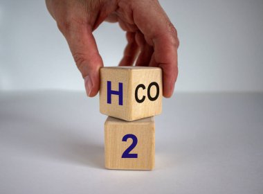 Yakıt hücreli araçlara geçin. Elle bir küp çevirir ve CO2 ifadesini H2 'ye çevirir. Güzel beyaz arka plan. Ekolojik kavram.