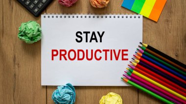 Üzerinde güzel ahşap masa, renkli kağıt, renkli kalemler ve hesap makinesi üzerinde 