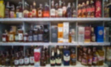 Alkol gösterisi arka planı bulanıklaştırdı. Süpermarketteki rafların soyut arkaplanı bulanık. Bokeh.