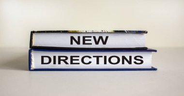 Güzel beyaz arka planda 'yeni yönler' yazılı kitaplar. İş konsepti, kopyalama alanı.