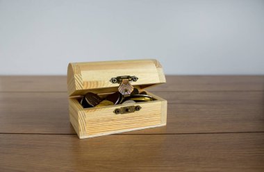 İş imajını kavra. Güzel ahşap bir masanın üzerinde bozuk paralar olan küçük bir sandık. Beyaz arkaplan, alanı kopyala.