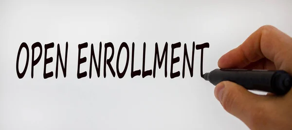 Hand writing \'open enrollment\', isolated on beautiful white background. Concept.