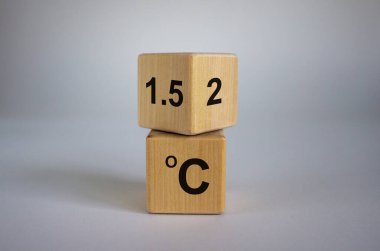 Küresel ısınmayı sınırlamanın sembolü. Küpü çevirdim ve '2 C' ifadesini '1.5 C' olarak değiştirdim, ya da tam tersi. Kavram. Güzel beyaz arkaplan, kopyalama alanı.