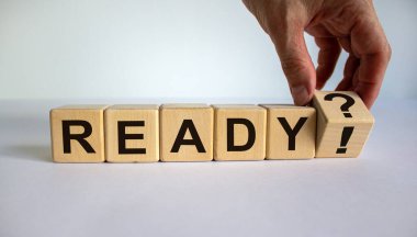 Tahta küplerde kelime 'hazır'. El küpü çeviriyor ve soru işaretini ünlem işaretiyle değiştiriyor. Güzel beyaz arka plan, kopyalama alanı. İş konsepti.