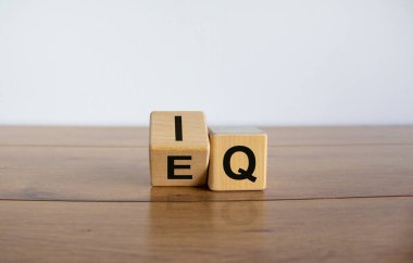 Tahta küplerde 'IQ' ifadesi 'EQ' ile 'Duygusal Zeka Miktarı' arasında fark var. Tahta masa. İş konsepti, kopyalama alanı. Güzel beyaz arkaplan.